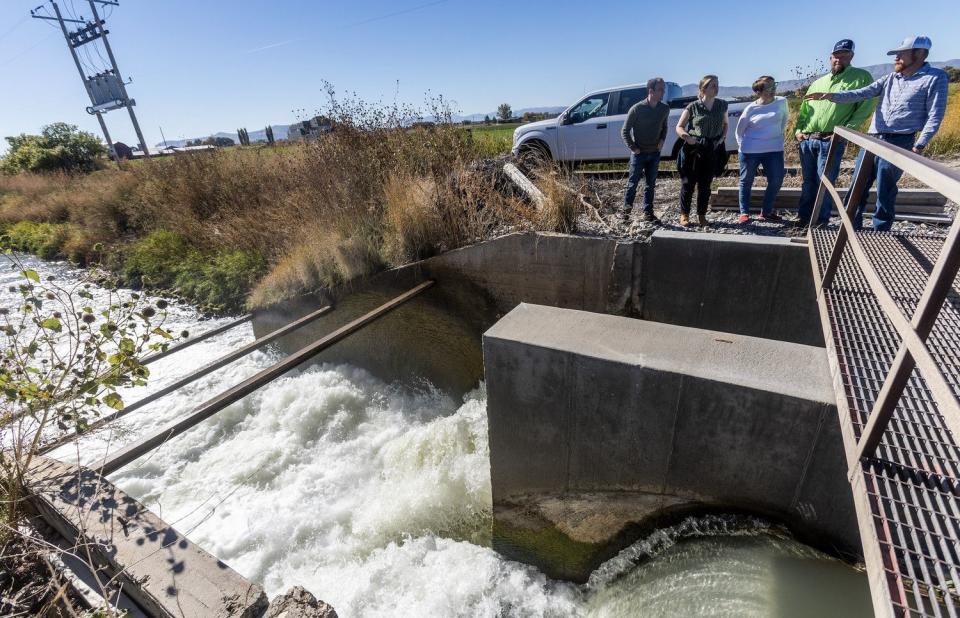 Trevor Nielson of the Bear River Canal Co., right, talks about the new, high-tech gates and other issues with water officials during a tour of various canal sites in Box Elder County on Oct. 19.