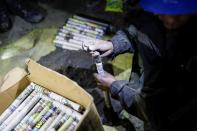 An artisanal gold miner makes dynamite sticks with newspaper before setting off an explosion inside a gold mine in La Rinconada, in the Andes