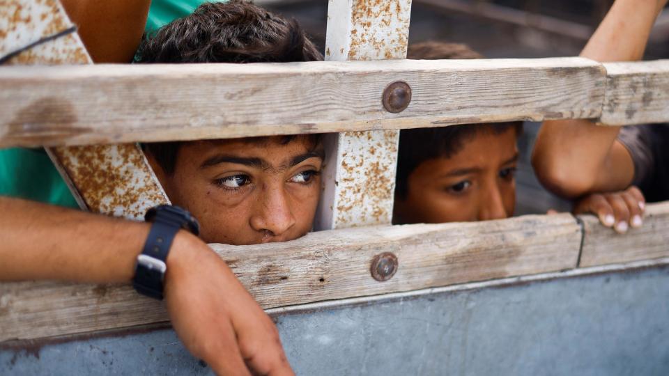 Niños miran dentro de un vehículo que transporta los cuerpos de los palestinos muertos en un ataque israelí contra un área designada para personas desplazadas, en Rafah, el 27 de mayo de 2024.