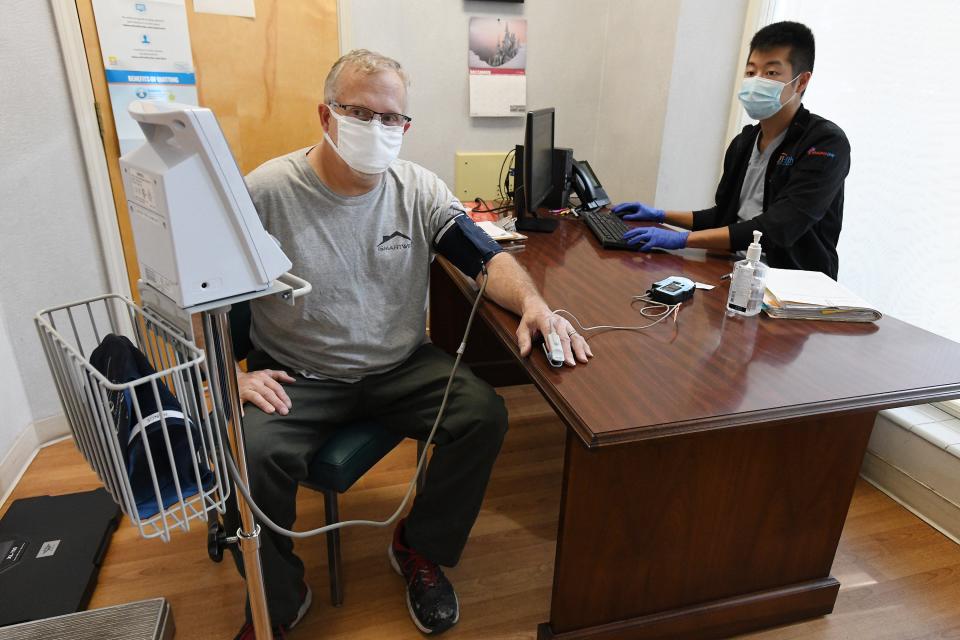 Patient Donald McCormick (left) goes through intake with EMT Andrew Rhee at the Volunteers in Medicine clinic in downtown Jacksonville. The clinic is part of the WeCareJax network, which provides free healthcare for uninsured patients.