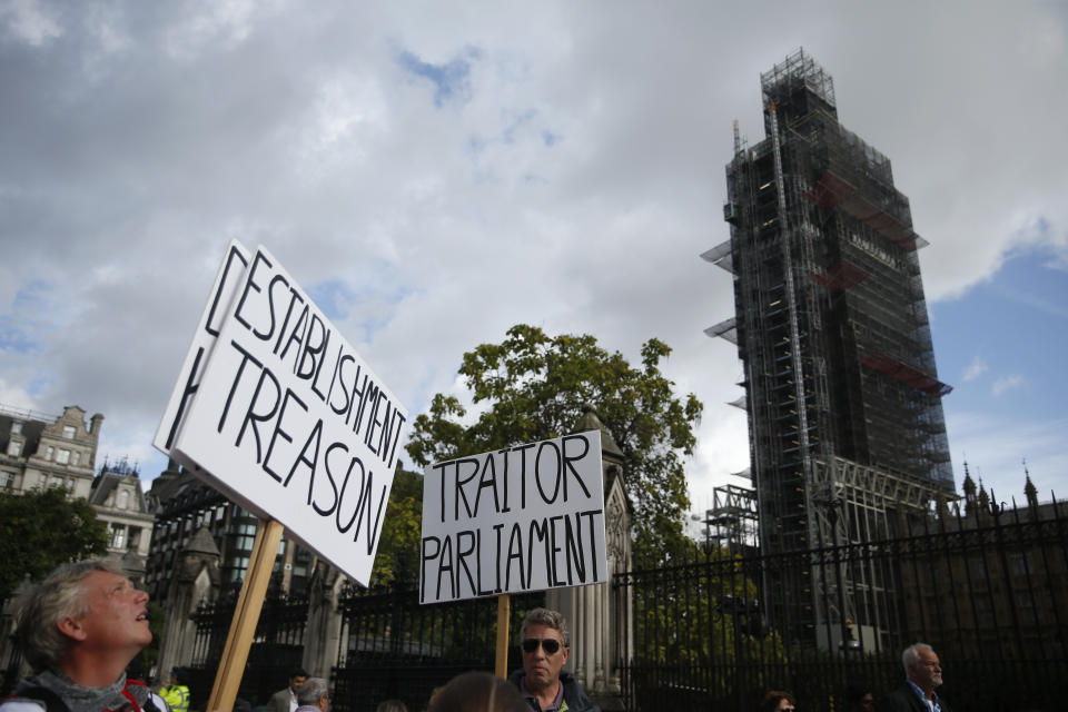 Brexit supporters hold placards outside the scaffolded tower known as Big Ben at the Houses of Parliament in London, Thursday, Sept. 26, 2019. British Prime Minister Boris Johnson faced a backlash from furious lawmakers Thursday over his use of charged and confrontational language in Parliament about opponents of his Brexit plan. (AP Photo/Matt Dunham)