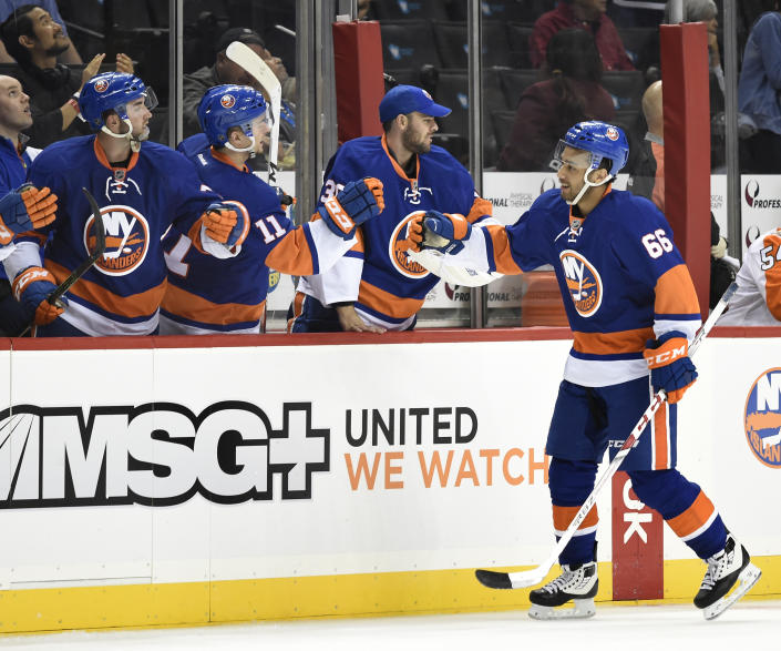 FILE- New York Islanders center Josh Ho-Sang (66) celebrates his goal against the Philadelphia Flyers with teammates in the third period of a preseason NHL hockey game in New York., Monday, Sept. 26, 2016. The 2022 Beijing Olympics will be the first time Josh Ho-Sang, the multirracial, multicultural Canadian ice hockey player, will visit China. "It really shows how far we've come as a society, to have these different faces representing home for everyone," Ho-Sang says. "A hundred years ago, you would never see such diversity in each country that you see now. It's a sign of hope and progress." (AP Photo/Kathy Kmonicek, File)