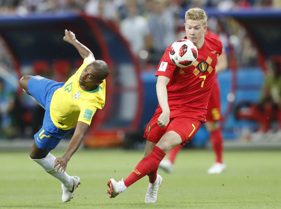 <p>Kevin De Bruyne holds off Fernandinho to win the ball off the Brazilian </p>