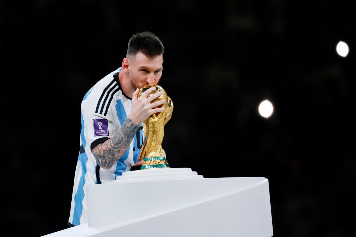 Argentina forward Lionel Messi kisses the World Cup Trophy after winning the 2022 World Cup final against France at Lusail Stadium in Qatar.