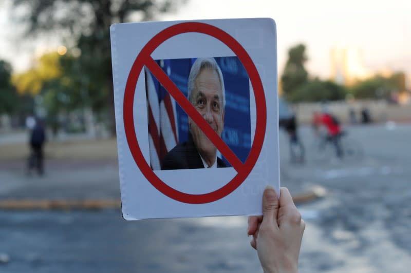 Imagen de archivo de un manifestante sosteniendo un cartel con una foto del presidente Sebastián Piñera, durante las protestas contra el Gobierno, en Santiago