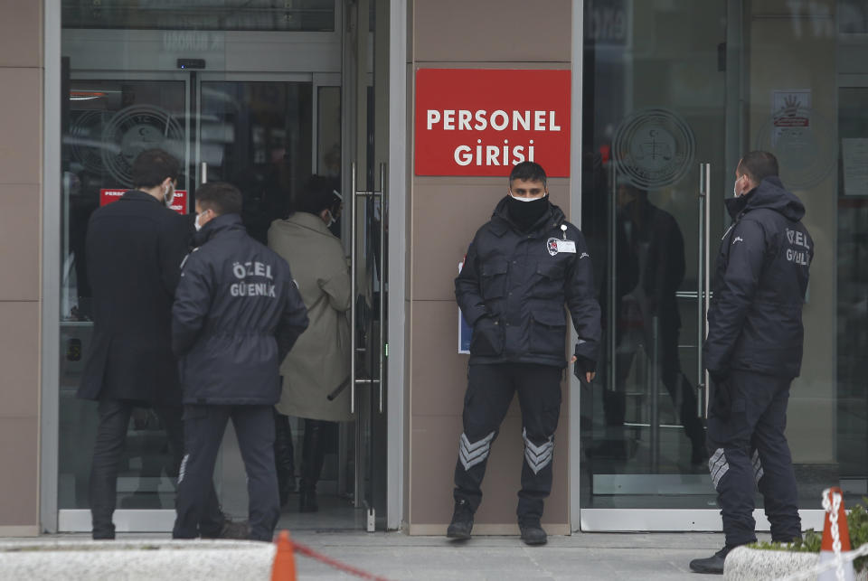 Security personnel guard the entrance to Istanbul's court Wednesday, Feb. 24, 2021, where the case of a Turkish private airline official and two pilots over their involvement in former Nissan Motor Co. chairman Carlos Ghosn's dramatic escape out of Japan in 2019 and to Beirut, Lebanon, was held. The court convicted a Turkish private airline official and two pilots and sentenced them each to four years and two months in prison. Ghosn, who was arrested over financial misconduct allegations in Tokyo in 2018, skipped bail while awaiting trial there. (AP Photo/Mehmet Guzel)