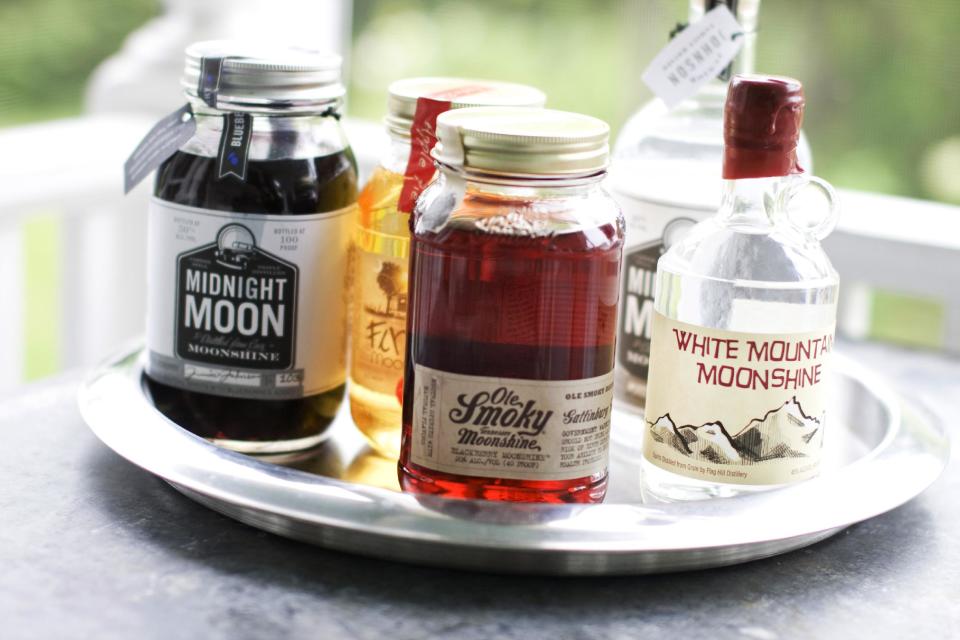 In this image taken on June 10, 2013, from left, Midnight Moon Blueberry, FireFly Moonshine Apple Pie Flavor, Ole Smoky Tennessee Moonshine Blackberry, Midnight Moon Moonshine, and White Mountain Moonshine are shown in Concord, N.H. (AP Photo/Matthew Mead)