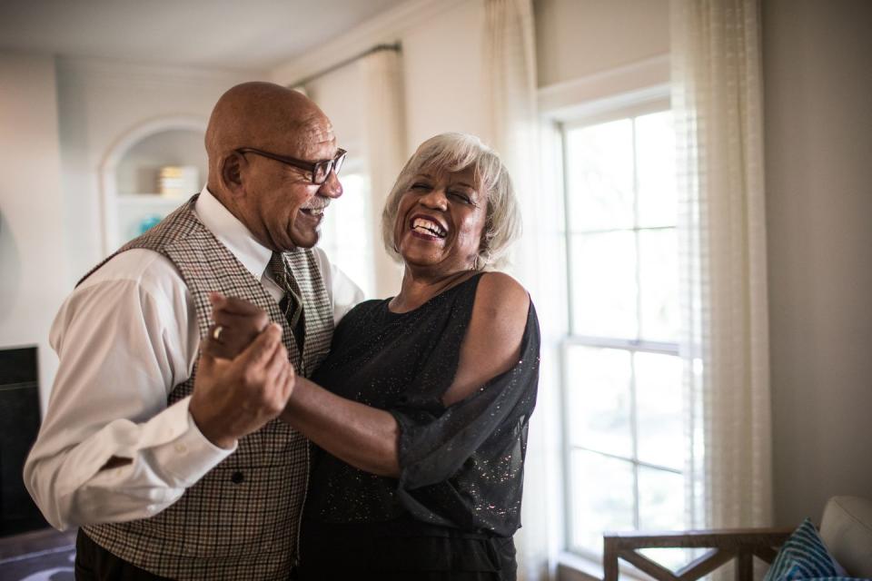 older couple dressed up for an at home date night, dancing, laughing