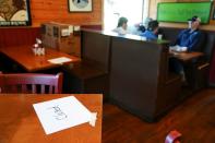 People eat lunch inside Moe's Original BBQ after it reopened to the public as part of the phased reopening of businesses from the coronavirus disease rules in Atlanta