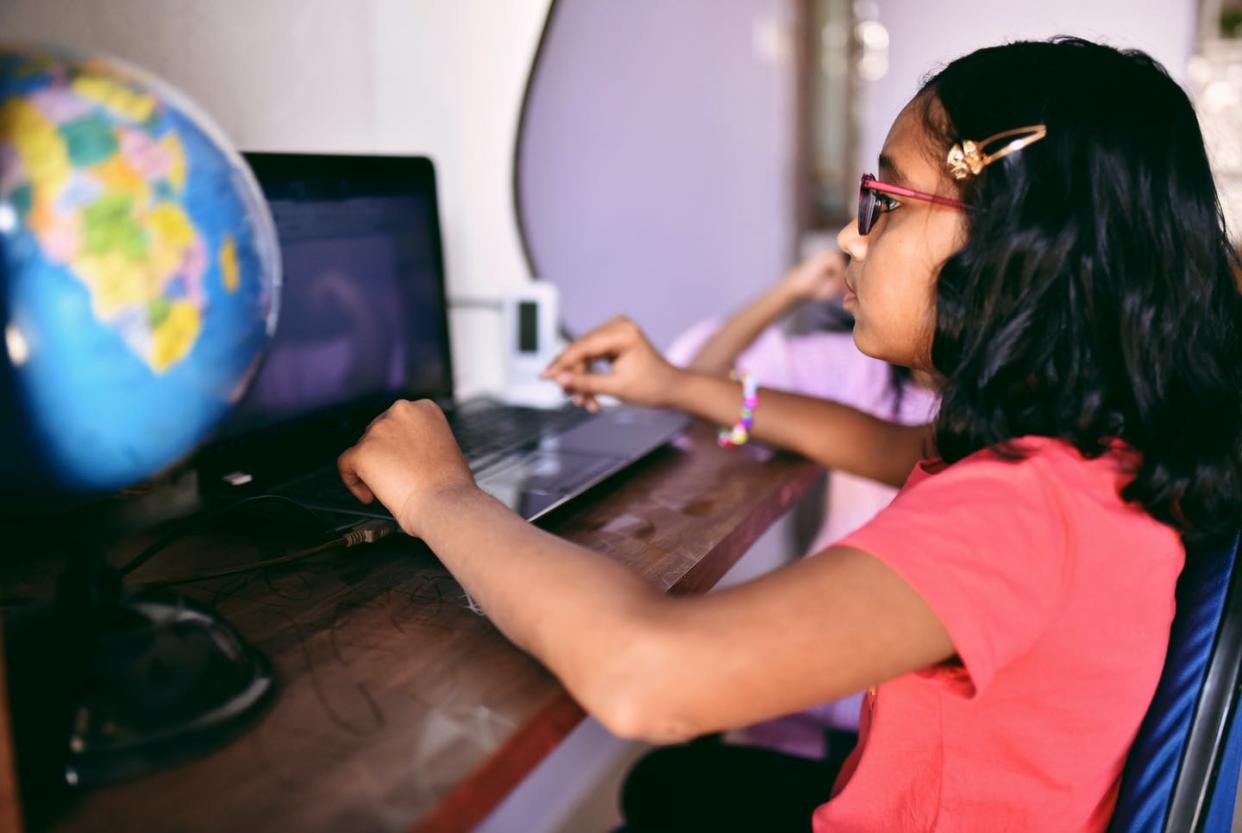 <span class="caption">Seventeen percent of students around the world lack a desk at home. </span> <span class="attribution"><a class="link " href="https://www.gettyimages.com/detail/photo/girl-doing-homework-on-laptop-royalty-free-image/1127705696?adppopup=true" rel="nofollow noopener" target="_blank" data-ylk="slk:Mayur Kakade/Getty Images;elm:context_link;itc:0;sec:content-canvas">Mayur Kakade/Getty Images</a></span>