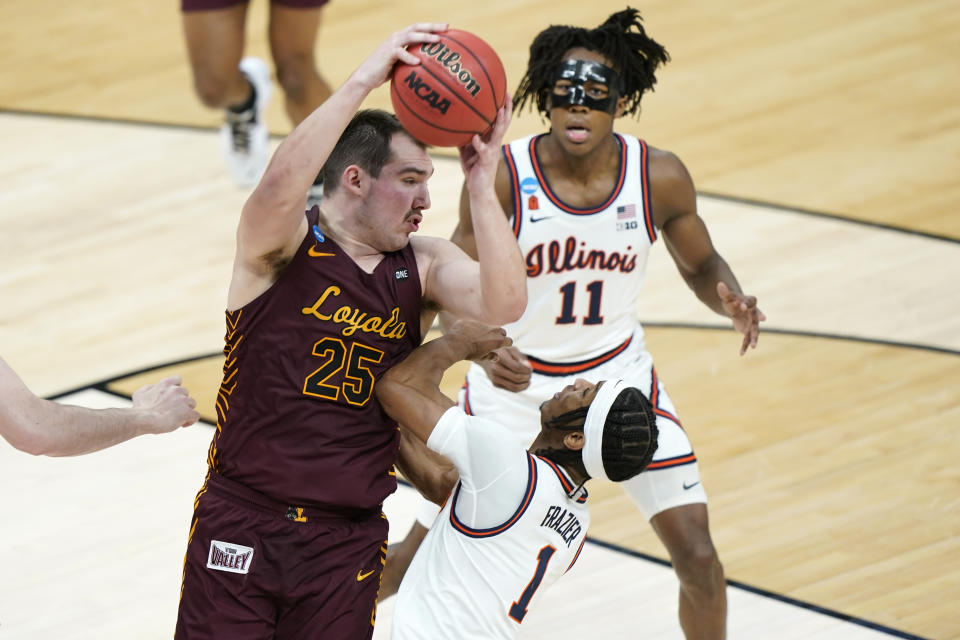 Loyola of Chicago's Cameron Krutwig (25) grabs a rebound above Illinois' Trent Frazier (1) during the first half of a college basketball game in the second round of the NCAA tournament at Bankers Life Fieldhouse in Indianapolis Sunday, March 21, 2021. (AP Photo/Mark Humphrey)