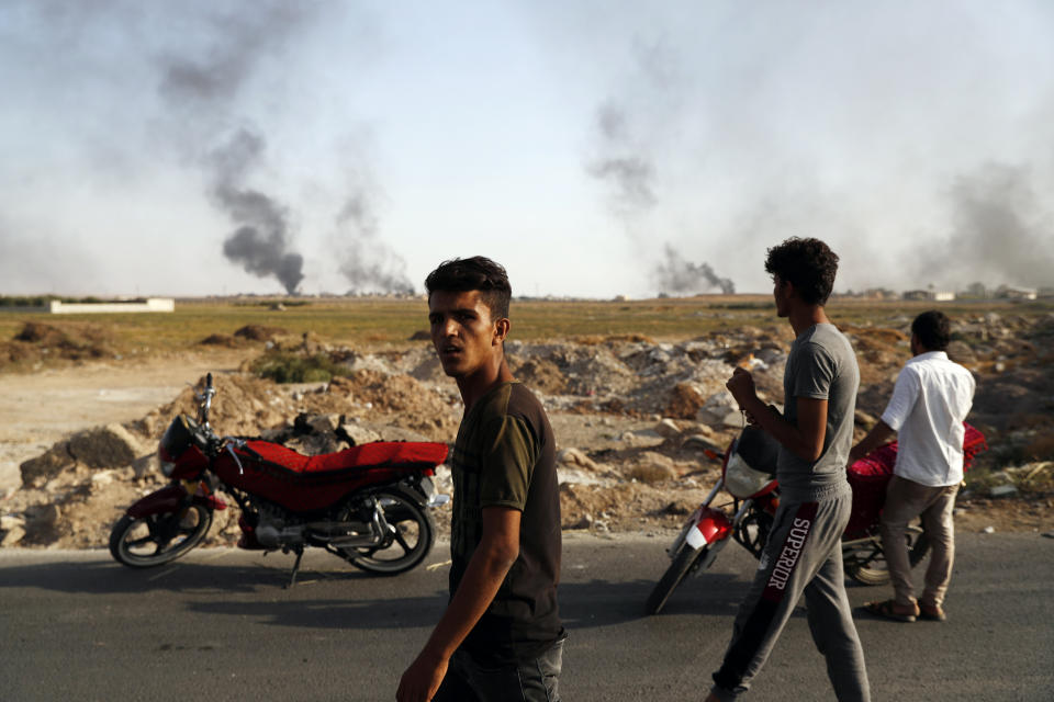 People in Akcakale, Sanliurfa province, southeastern Turkey, at the border with Syria, watch smoke billowing from targets inside Syria, during bombardment by Turkish forces, Oct. 10, 2019. (Photo: Lefteris Pitarakis/AP )