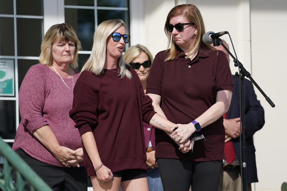 Hollie Skaggs, second from left, holds hands with Sara Wiles as they both speak during a prayer vigil at the Collierville Town Hall, Friday, Sept. 24, 2021, in Collierville, Tenn. Both Skaggs and Wiles were shopping in a Kroger grocery store Thursday when a gunman attacked people, killing one and injuring several, before he was found dead of an apparent self-inflicted gunshot wound. (AP Photo/Mark Humphrey)