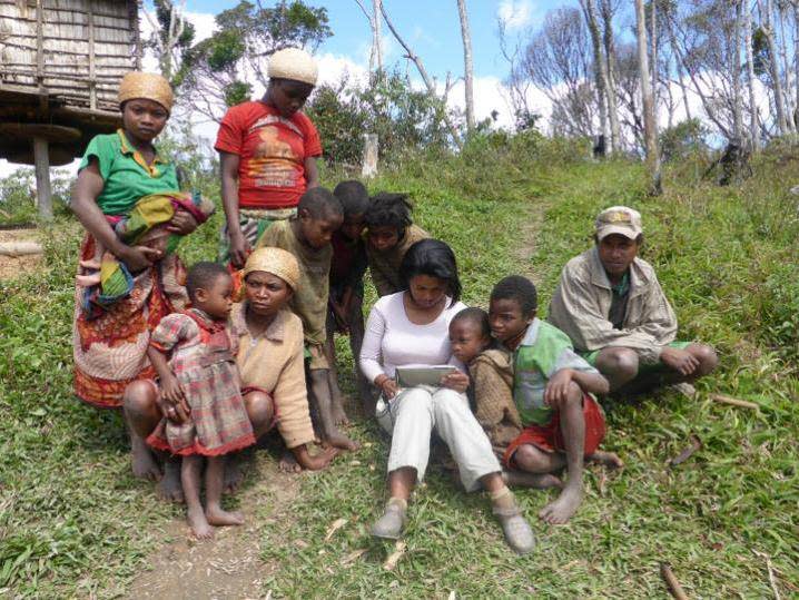 Co-author Rina Mandimbiniaina entering data from an interview for the study, watched by a participating household (S Rakotonarivo)