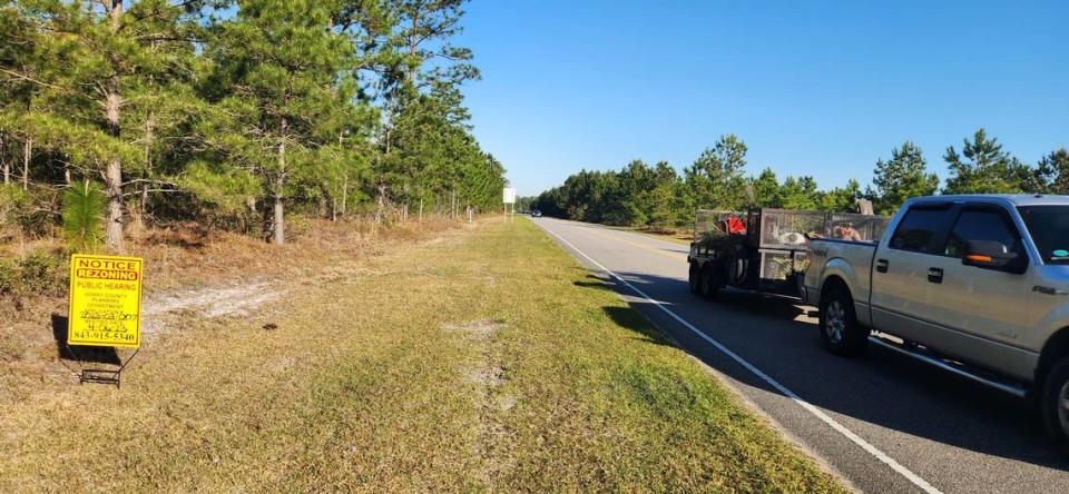 A motorist travels down Postal Way on March 30, 2023. The wooded area could give way to more than 1,000 homes and retail if county leaders approve development plans.