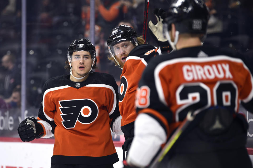 Philadelphia Flyers' Travis Konecny, left, celebrates with Jakub Voracek, center, and Claude Giroux after Konecny scored a goal past Boston Bruins goaltender Jeremy Swayman during the first period of an NHL hockey game, Saturday, April 10, 2021, in Philadelphia. (AP Photo/Derik Hamilton)