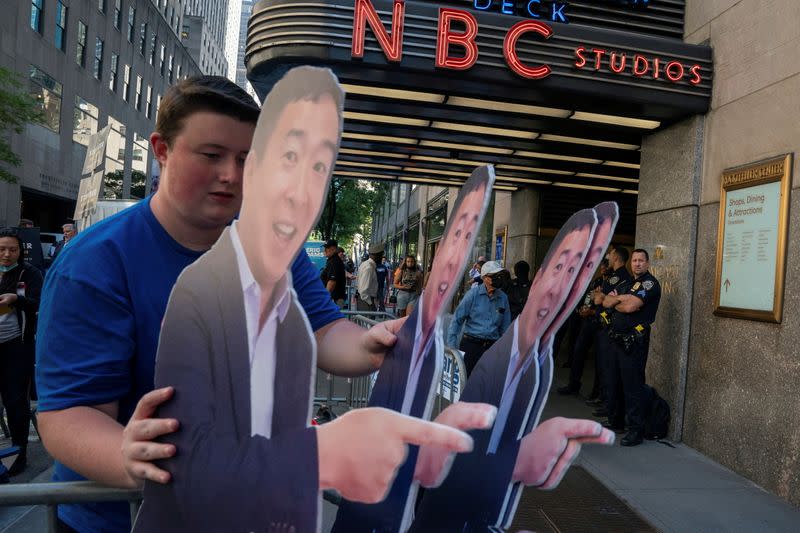 FILE PHOTO: A supporter carries life size cutouts of New York City Mayoral hopeful Andrew Yang at the Democratic primary debate in New York City