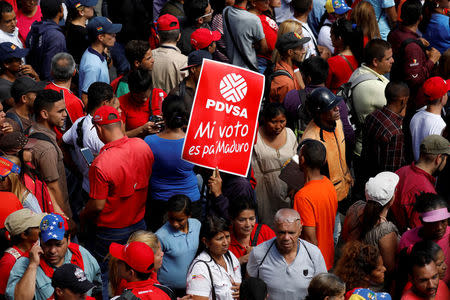 FILE PHOTO: The corporate logo of the state oil company PDVSA is seen in a banner that reads "My vote is for Maduro" during a rally with Venezuela's President Nicolas Maduro outside the National Electoral Council (CNE) headquarters after he registered his candidacy for re-election, in Caracas, Venezuela February 27, 2018. REUTERS/Marco Bello/File Photo