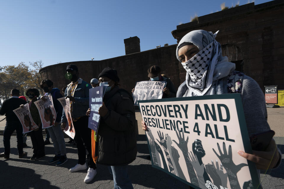 FILE - In this Nov. 9, 2020, file photo, Yafa Dias holds a sign at an immigration reform rally in New York. Those at the rally are asking President-elect Joe Biden to prioritize immigration reform. (AP Photo/Mark Lennihan)