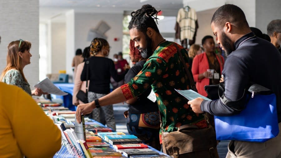 Marcus Smith, 30 (center), an University of Massachusetts at Amherst doctoral candidate, looks at books in between presentations during the 47th Annual National Council for Black Studies Conference in March. Amherst is considering spending the proceeds of the college town’s $2 million in reparation funds for Black residents on youth programs, affordable housing and grants for businesses. (Photo: Lauren Witte/USA TODAY NETWORK)