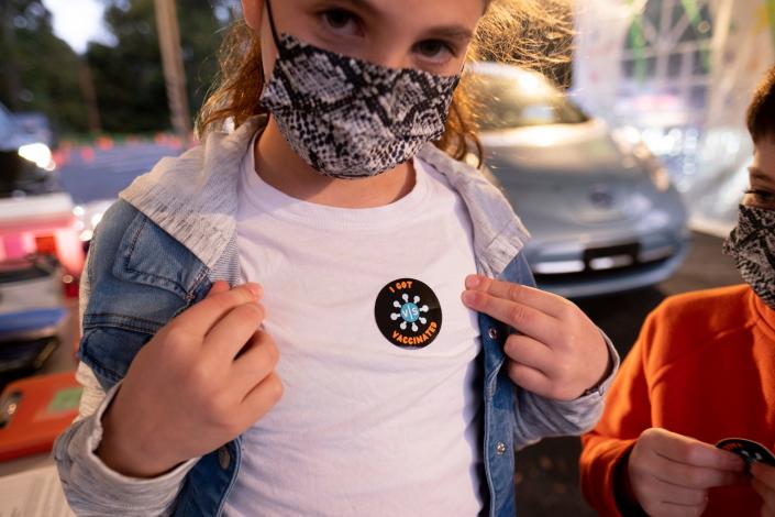 Leah Lefkove, 9, shows off her vaccination sticker just before being the first child to be vaccinated at the Viral Solutions vaccination and testing site in Decatur, Georgia, on the first day COVID-19 vaccinations were available for children from 5 to 12 on Nov. 3, 2021.