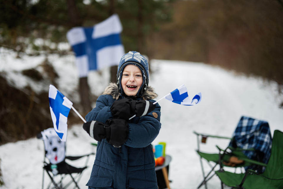 Finnish boy with Finland flags on a nice winter day