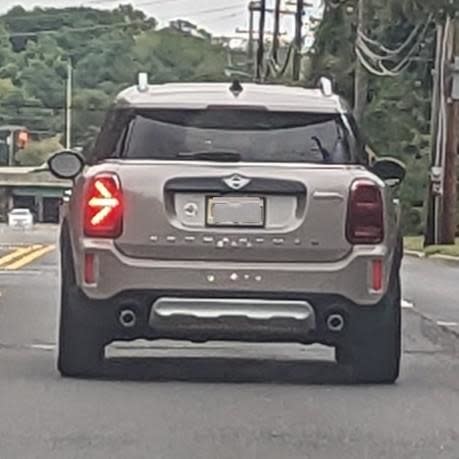 A silver Mini Cooper car stopped at a traffic light