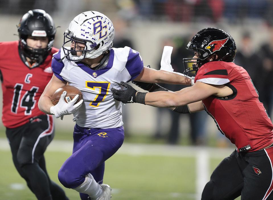Bloom-Carroll's Dylan Armentrout stiff arms Canfield's Vince Makovits as Anthony Mazella,14, moves in for the first-half tackle during the Division III state final at Tom Benson Hall of Fame Stadium in Canton, Friday, Dec. 2, 2022.