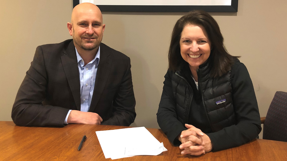 Mike Hentges, St. Raymond's Society co-founder, and Kathleen Bruegenhemke, Ronald McDonald House board president, sign a commitment for the sale of the Ronald McDonald House in Columbia.