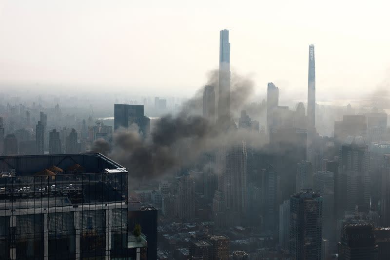 Smoke is visible after a construction crane caught fire on a high-rise building in Manhattan, New York