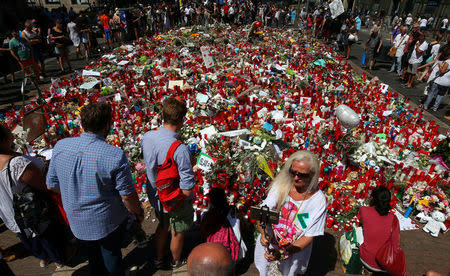 A woman takes a selfie in front of an impromptu memorial at the site where a van crashed into pedestrians at Las Ramblas in Barcelona, Spain, August 22, 2017. REUTERS/Albert Gea