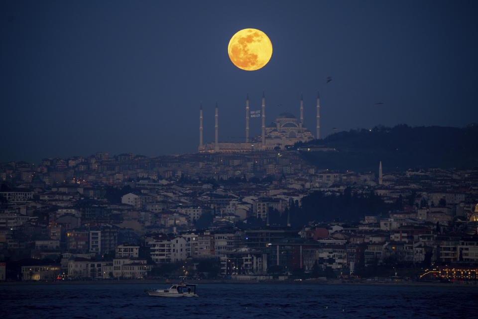 A full moon rises behind the Camlica mosque in Istanbul, Turkey, Saturday, Feb. 24, 2024. (AP Photo/Emrah Gurel)