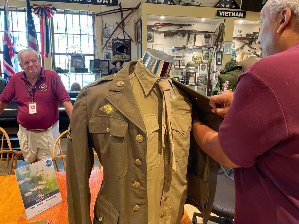 Paul Souza of the Fort Taber-Fort Rodman Military Museum assembles the uniform that was worn by the late E. Milton Silvia, a longtime Standard-Times photographer, as Bob Lytle from the museum looks on.