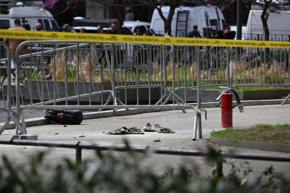 Fire extinguishers (R) are left at the park across from Manhattan Criminal Court in New York City after a man reportedly set himself on fire during the trial of former President Donald Trump, in New York City on April 19, 2024. A man set himself on fire Friday outside the court, New York police said, with officers rushing to extinguish the flames. TV reporters described the scene that unfolded moments after the full panel of 12 jurors and six alternates was selected for the trial of the former president in a hush money cover-up case.