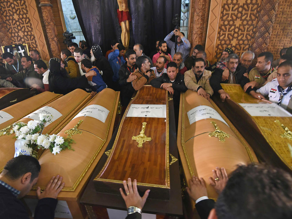 Mourners pray next to coffins of victims of the blast at the Coptic Christian Saint Mark's church in Alexandria: Getty Images