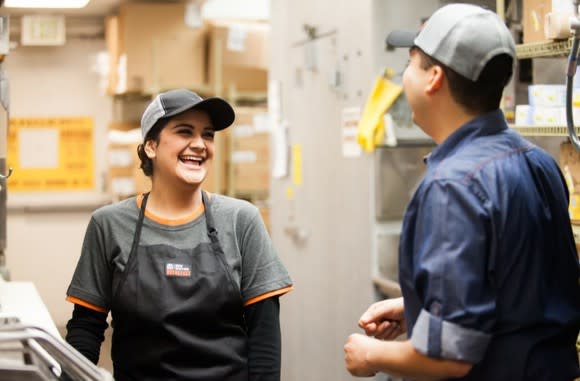 A Taco Bell workers talks to another Taco Bell worker.