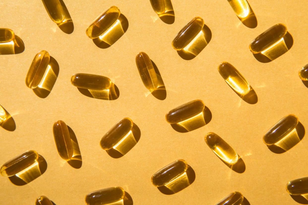 soft fish oil capsules with omega 3 on a golden background