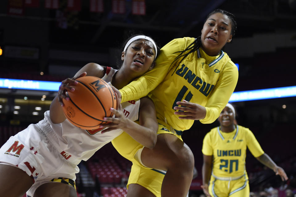 Maryland's Angel Reese, left and UNC Wilmington's Dazia Powell struggle for the ball during the first half of an NCAA college basketball game on Thursday, Nov. 18, 2021, in College Park, Md. (AP Photo/Gail Burton)