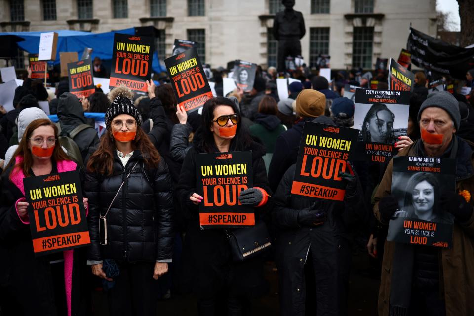 Demonstrators against UN Women hold pictures of Israeli women being held hostage in Gaza during a rally in London on Dec. 3, 2023.