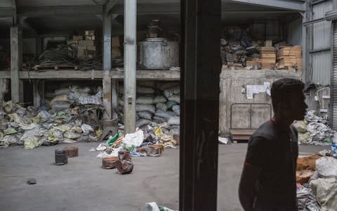 A Bangladeshi worker walks through a copper reclamation factory owned by Insaf Ibrahim, a suspected bomber, along with his brother Ilham - Credit:  Sam Tarling