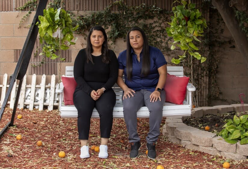 NORWALK, CA-MAY 27, 2022: Katherine Garcia, 21, left, and her sister Johanna Garcia, 27, are photographed at their home in Norwalk. They are the daughters of Enrique Garcia, a 49 year old Santa Ana man and forklift operator who died in December of 2017 after a medical procedure at South Coast Global Medical Center. The Garcia sisters sued a gastroenterologist for negligence but lost at trial last moth on Orange County civil court. After the verdict, Robert McKenna III, an attorney representing the doctor, appeared in a social-media post celebrating the verdict in a way that sparked controversy. (Mel Melcon / Los Angeles Times)