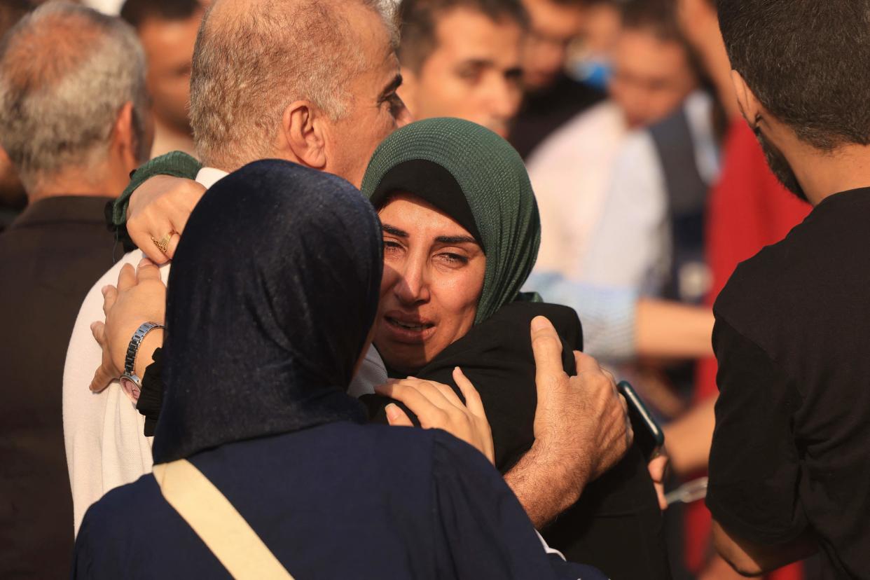Mourners hug each other during the funeral of people killed in Israeli strikes earlier in Khan Yunis (AFP via Getty Images)