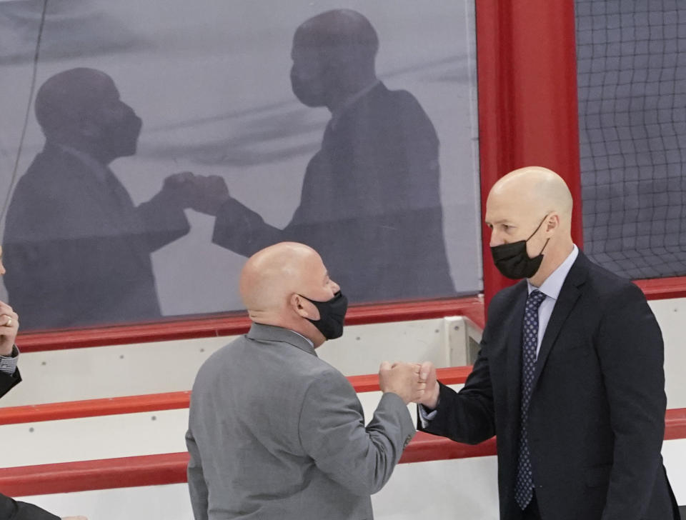 St. Cloud State head coach Brett Larson, right, greets Minnesota State head coach Mike Hastings after defeating Minnesota State in an NCAA men's Frozen Four hockey semifinal in Pittsburgh, Thursday, April 8, 2021. St. Cloud State won 5-4 to advance to the championship game Saturday. (AP Photo/Keith Srakocic)