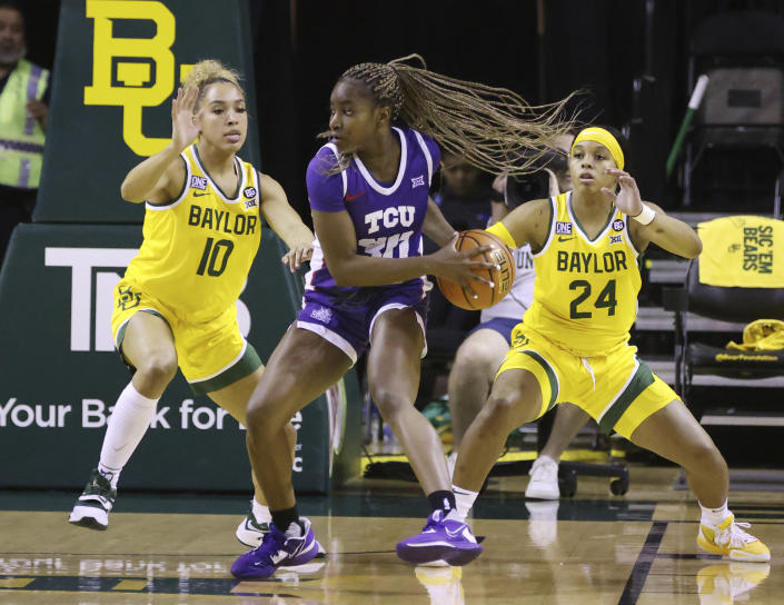TCU guard Roxane Makolo (30) sets up an offensive play between Baylor guard Jaden Owens (10) and Sarah Andrews (24) in the first half of an NCAA college basketball game, Saturday, Dec. 31, 2022, in Waco, Texas. (Rod Aydelotte/Waco Tribune-Herald via AP)