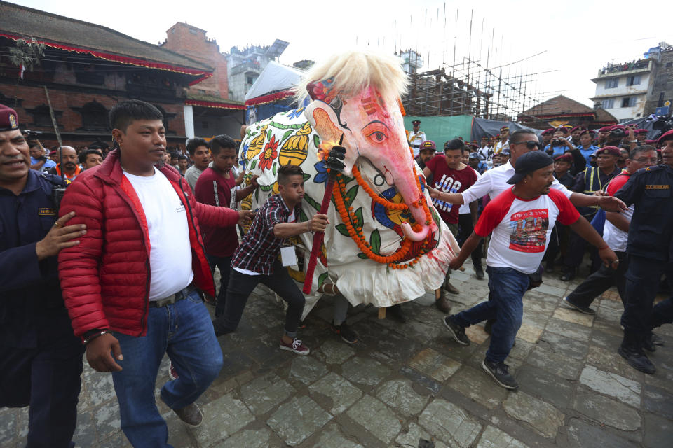 Nepalese devotees perform a traditional elephant dance during Indra Jatra festival, an eight-day festival that honors Indra, the Hindu god of rain, in Kathmandu, Nepal, Friday, Sept. 13, 2019. Families gather for feasts and at shrines to light incense for the dead, and men and boys in colorful masks and gowns representing Hindu deities dance to the beat of traditional music and devotees' drums, drawing tens of thousands of spectators to the city's old streets. (AP Photo/Niranjan Shrestha)