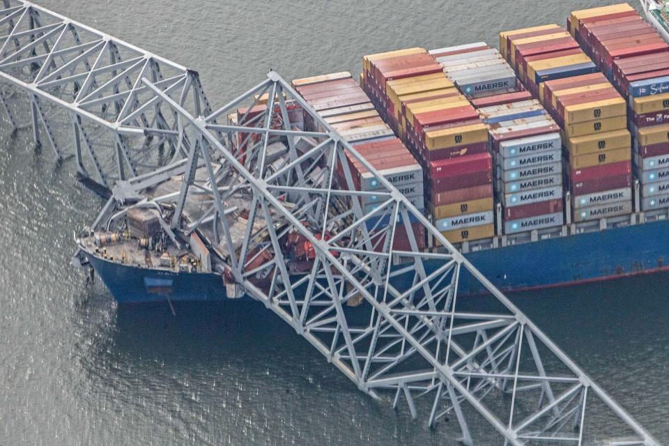 Segments of the collapsed Francis Scott Key Bridge rest on the container ship Dali in Baltimore, Tuesday, March 26, 2024. Six people are missing after the Dali lost power and crashed into one of the bridge's support columns.