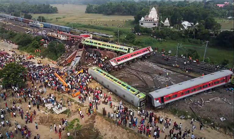 Esta captura de pantalla hecha a partir de imágenes de video muestra a personas reunidas en el lugar del accidente de una colisión de tres trenes cerca de Balasore, a unos 200 km de la capital de Bhubaneswar