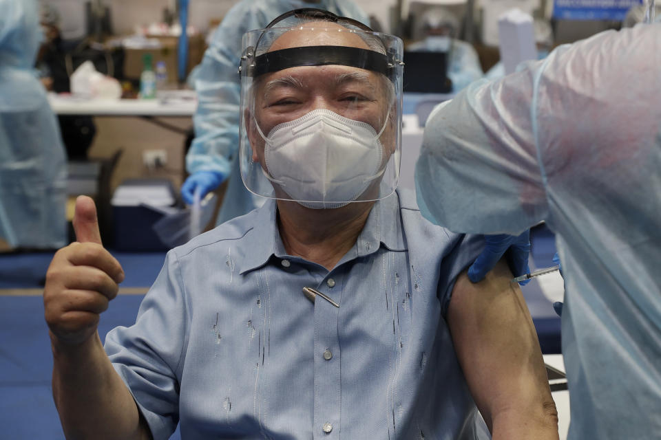 An elderly man flashes the thumbs up sign as he is inoculated with Russia's Sputnik V COVID-19 vaccine inside the Makati Coliseum in Manila, Philippines on Tuesday, May 4, 2021. The Philippines started a simultaneous vaccination of the initial 15,000 doses of Russia's Sputnik V COVID-19 vaccines that arrived in the country earlier this week. (AP Photo/Aaron Favila)