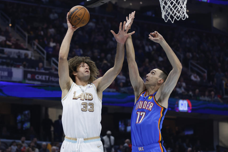 Cleveland Cavaliers center Robin Lopez (33) shoots against Oklahoma City Thunder forward Aleksej Pokusevski (17) during the first half of an NBA basketball game Saturday, Dec. 10, 2022, in Cleveland. (AP Photo/Ron Schwane)