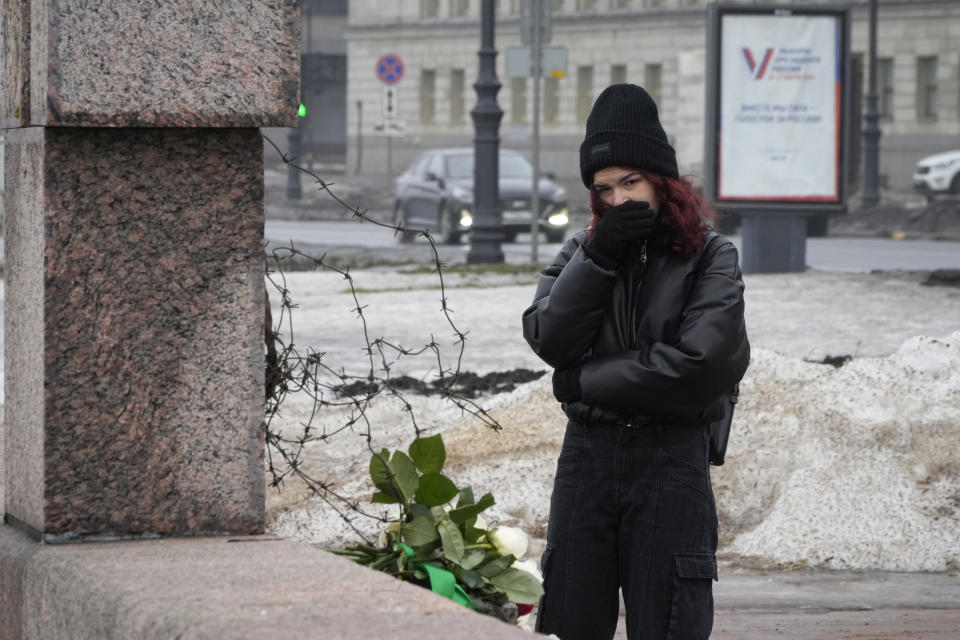 A woman reacts as she came to lay flowers paying the last respect to Alexei Navalny at the Memorial to Victims of Political Repression in St. Petersburg, Russia, Saturday, Feb. 24, 2024. Navalny, 47, Russia's most well-known opposition politician, unexpectedly died on Feb. 16 in the penal colony, prompting hundreds of Russians across the country to stream to impromptu memorials with flowers and candles. (AP Photo/Dmitri Lovetsky)